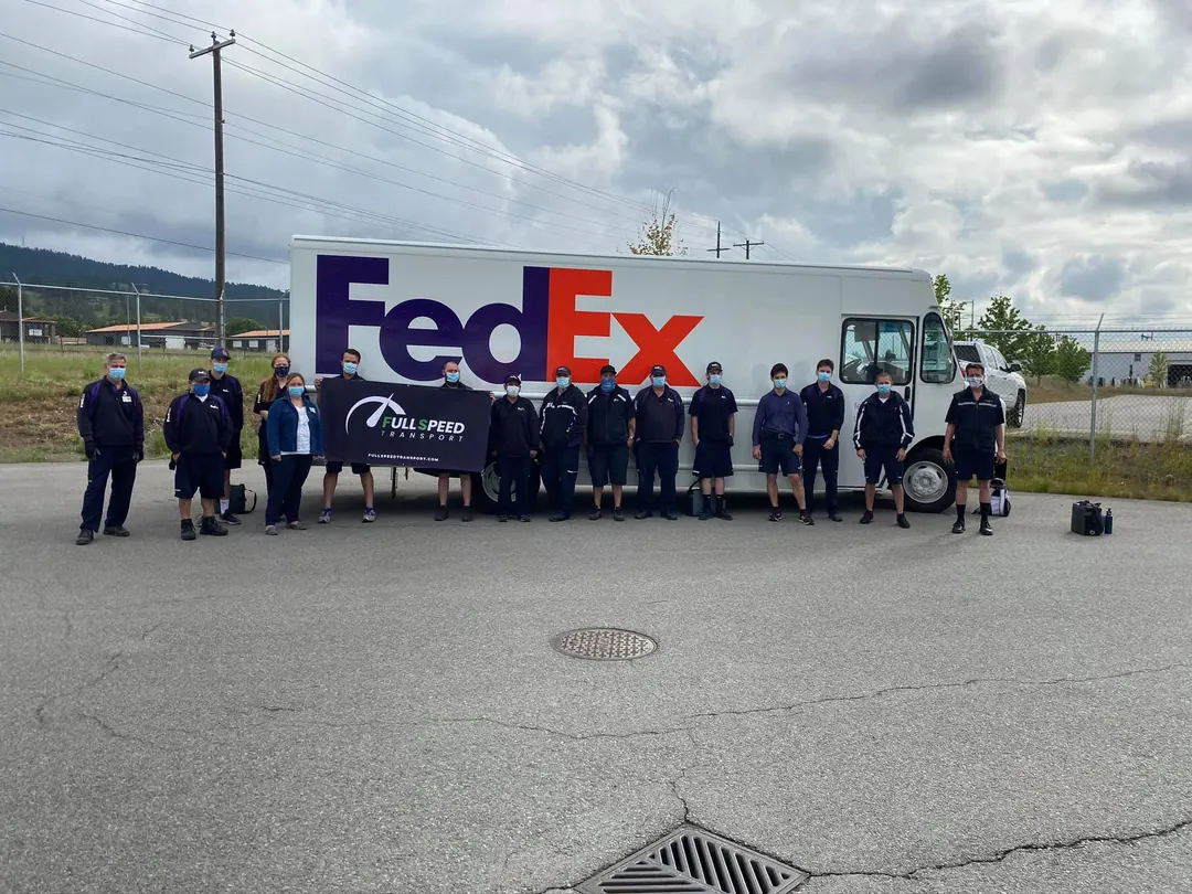 The Full Speed Transport team in front of a FedEx Ground truck